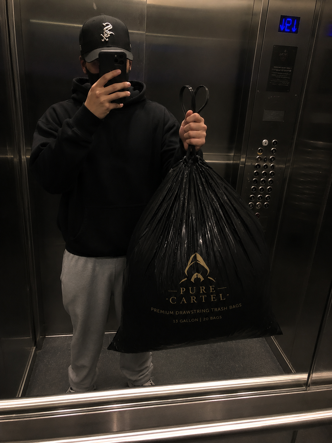 Elevator mirror photo holding a full Pure Cartel bag